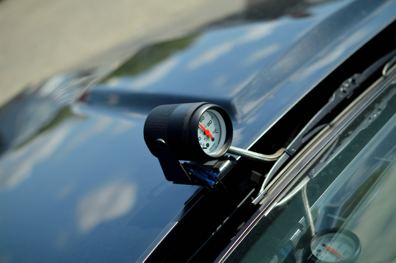 A lone fuel pressure gauge mounted to the hood of a buick GNX